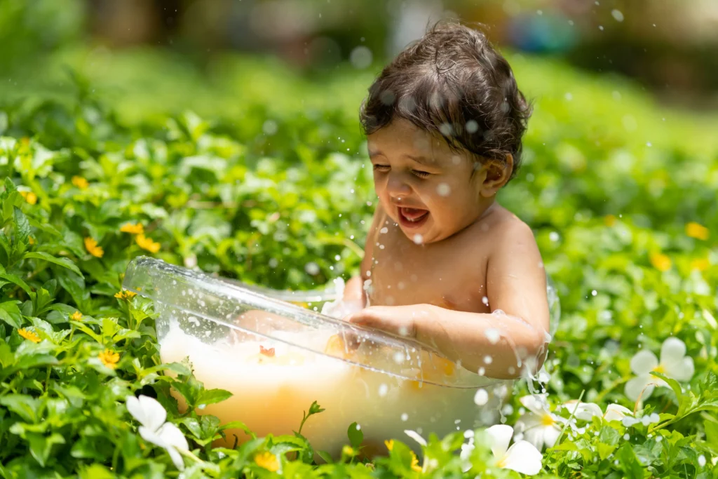 Baby laughing during a playful outdoor photoshoot in Ahmedabad.