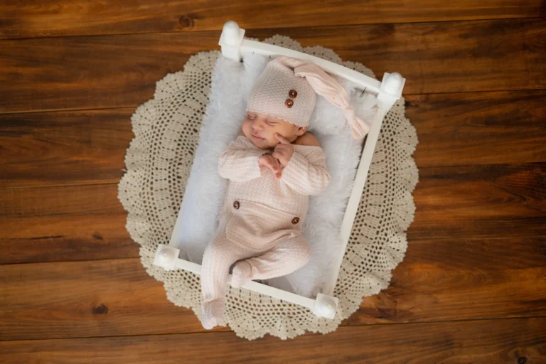 Sleeping newborn wrapped in soft pink, embodying serenity in a tranquil Ahmedabad photoshoot.